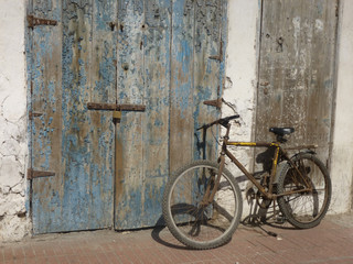 Fototapeta na wymiar Bicycle leaning against weathered wooden door with lock