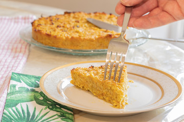 Homemade Roasted vegetable quiche pie with a wedge cut out. Delicious vegetarian food. freshly baked
Onions carrots squash courgettes KUGEL 
1 slice in a plat with a fork eating 