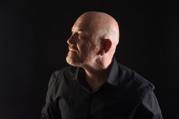 Obraz premium portrait of a man in low key, smiling and look to up