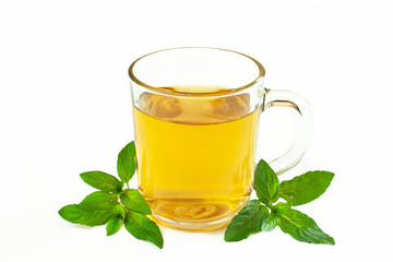 A glass of mint tea surrounded by sprigs of fresh mint on a white background

