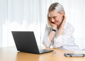 A young girl works with a laptop at home or in the office. antiviral mask