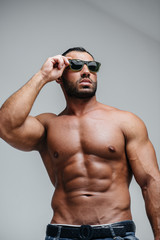 A sexy athlete with a naked torso is wearing glasses. Rest, healthy lifestyle