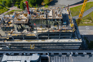 Aerial view of construcion site. People working. Top view of new apartment under construction. Picture made by drone from above.