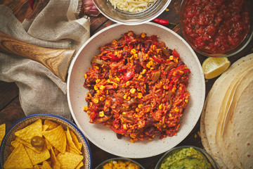 Preparing vegetable burritos on white pan. With various ingredinets for mexican food