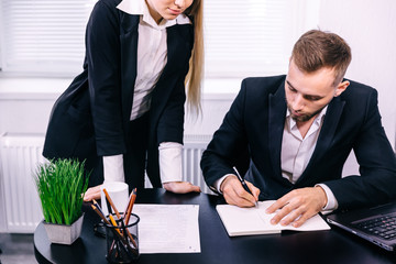 Business coleagues brainstorming. man writes ideas in notebook