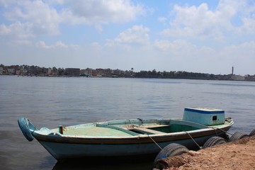 Naklejka na ściany i meble Empty small blue boat sitting on the Nile shore in Rosetta town 