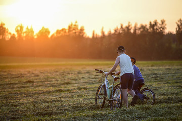 Obraz premium Children walk across the field in the rays of the sunset