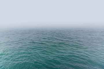 Fog on the sea. Seascape with waves and fog on the horizon.