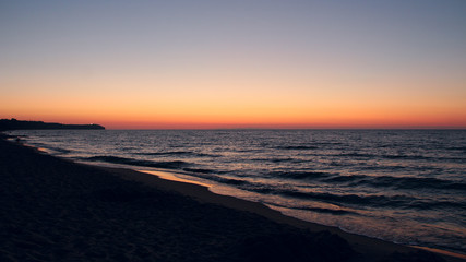 Sunset on Baltic Sea. Waves on seashore in evening