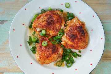 Close up Picture of vintage porcelain plate with roasted hot spicy chicken legs and chopped spring onion. Simple but tasty and juicy delicious light dish, with balanced nutritions and rich in protein.