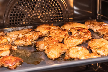 fried slices of chicken fillet on a metal grill in the oven. Cooking poultry