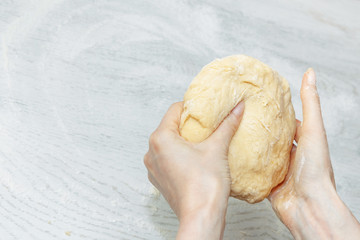 girl is holding a raw dough for buns. the concept of home cooking. making homemade dough