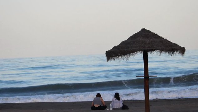 Sombrilla de paja en la playa al atardecer 