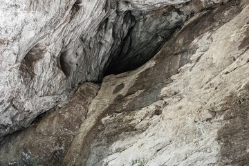 A cave in the rock. Concept archaeology, geology, research and excavation. mountain nature