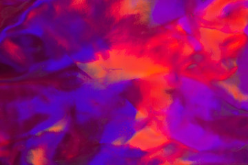 Trendy holographic foil texture background in satorated neon pink violet and orangecolors. Neon colored leather texture abstract backdrop for your design