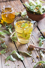 Harvesting healing herbs, linden flower tea and honey on a wooden background, alternative medicine