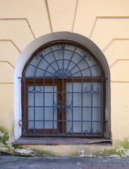 A basement window with a metal barrier