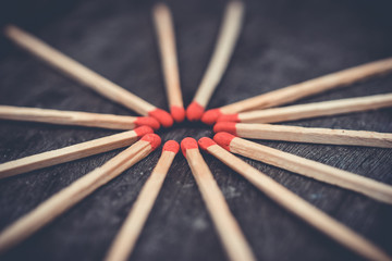 Matchstick with a red circle-shaped head on a wooden background.