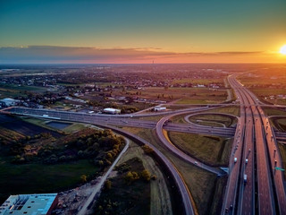 A beautiful panoramic aerial drone view of the sunset on the highway overpass of the southern...