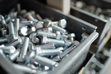Close-up of silver screws placed in metal box, repairman or furniture maker workplace concept - obrazy, fototapety, plakaty