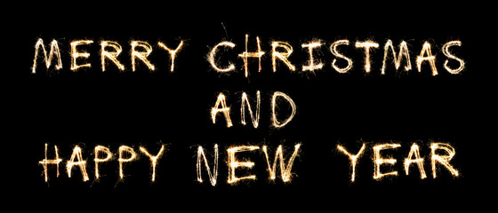 Happy New Year and Merry Christmas greeting text written sparkling sparklers isolated on black background and copy space.