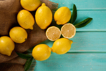 Yellow lemons on green wooden background
