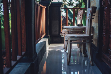 Summer backyard with wooden chairs and a table, green grass and bushes