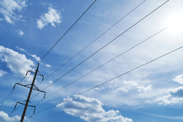 high-voltage electric line against a bright beautiful sky