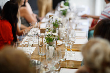 Tables setting at a luxury wedding. Table for guests. Dishes and drinks. Floral decorating, white chairs and table. Wedding table preparation. top view. Horizontal photo