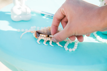 Bride and groom exchanging wedding rings close up during symbolic nautical decor destination wedding marriage on sandy beach in front of the ocean in Punta Cana, Dominican republic 