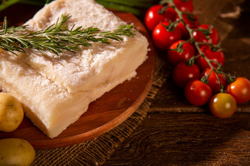 salted codfish on the wooden table with ingredients. Codfish raw.