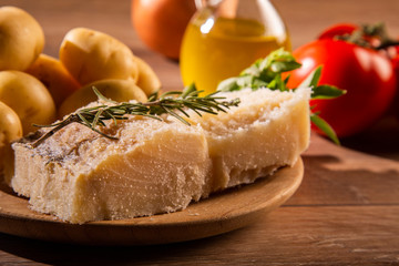 salted codfish on the wooden table with ingredients. Codfish raw.