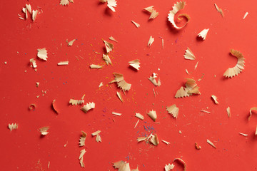 color pencil shavings and pencils on a red background