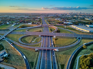 A beautiful panoramic aerial drone view of the sunset on the highway overpass of the southern...