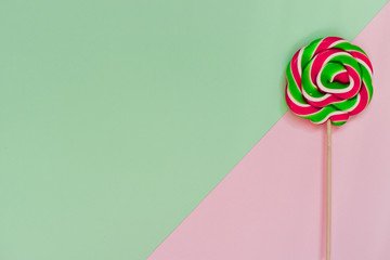 One bright green-red lollipop on a geometric background.