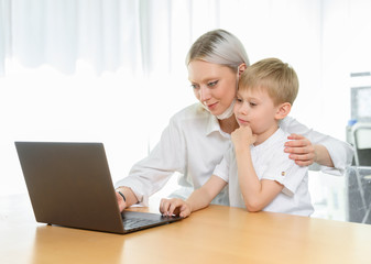 Boy child and girl study at a laptop at home.