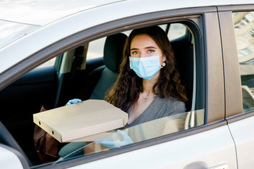 Business woman with pizza box in car. Delivery food service drive by car. Safe food delivered...