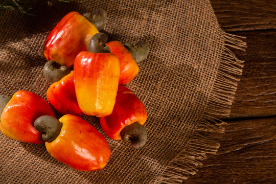 cashew fruit over a  wooden surface.