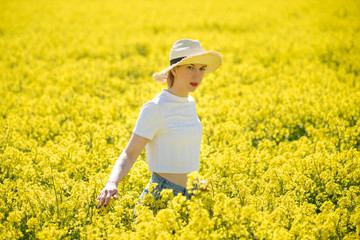 Fototapeta premium Young woman stands in a rape field
