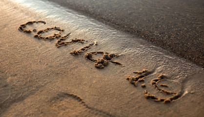 
the word covid-19 is painted in the sand