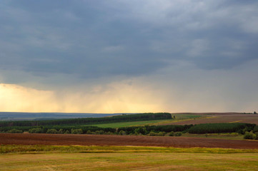 Obraz premium Thunderclouds and rain in the distance over Russian fields