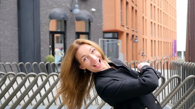 Young funny woman peeks out and looking with smile at the camera