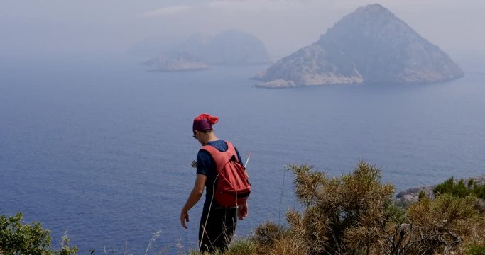 Traveller enjoys the view to an unhabited islands in Gelidonya cape in Mediterranean sea, Antalya, Turkey. Windy weather.