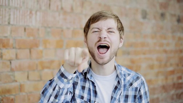 Cheerful Young Man Gesturing Loser Sign