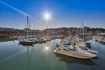 Fototapeta na wymiar Image of St Helier Marina North section from the West Marina wall, early morning with blue skys and sunshine. Jersey, Channel Islands, UK