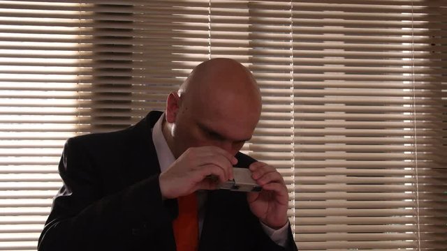 A spy photographs secret documents with a small camera. Collecting dirt on applicants, undercover work of a special AGENT, intelligence and agents.