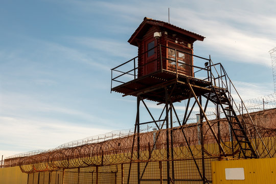 Prison tower and barbed wire fence. Wooden tower with room for guard of prisoners in pre-trial detention center or prison zone