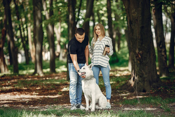 Naklejka na ściany i meble Couple in a forest. Pair playing with a cute dog