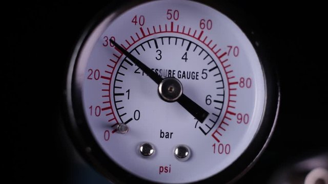 Air compressor manometer close-up slowly decreasing the pressure measurement