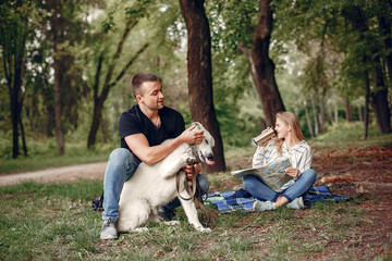 Fototapeta premium Couple in a forest. Pair playing with a cute dog